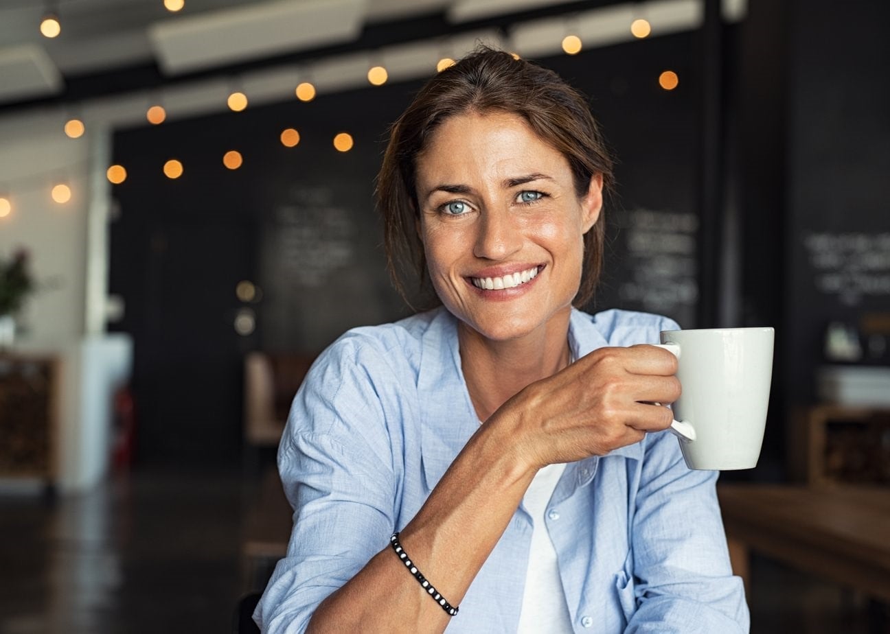Smiling MBA student holding a mug.